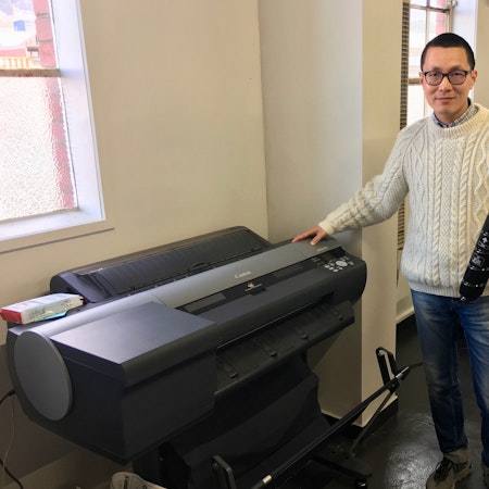 Alex standing by the large format inkjet printer